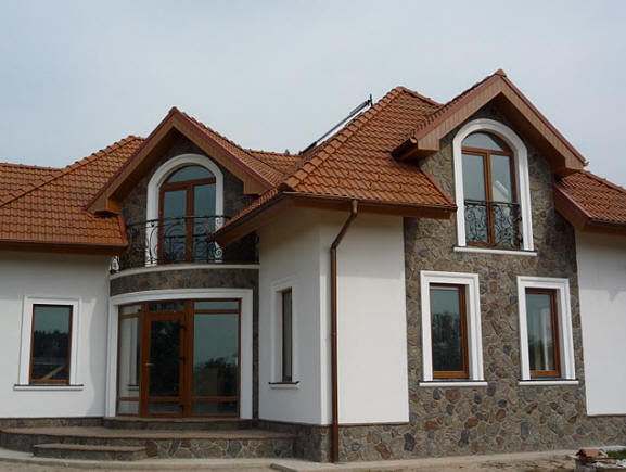 Фото: Комбинирование финишной шпатлевки и фасадного камня на фасада дома